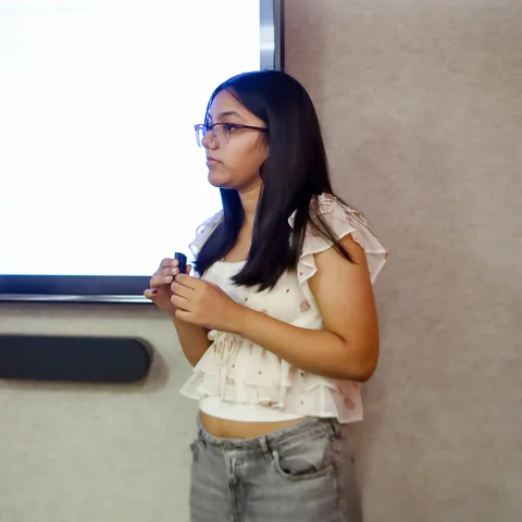 A student presenting beside the workshop screen